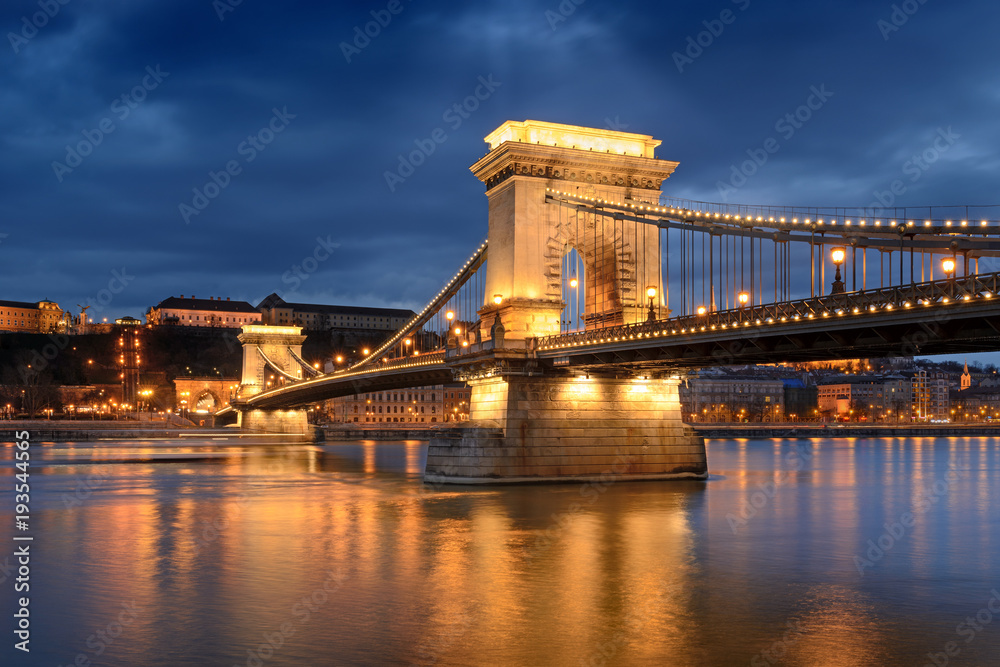 Fototapeta premium Chain bridge in Budapest under light beam through clouds at night