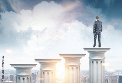 Businessman on a column in a city photo