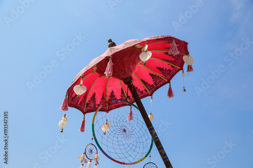 Colorful ethnic place, boho style decor. Outdoor or indoor decoration. Umbrellas with yellow orange and violet colors. Energy colors.