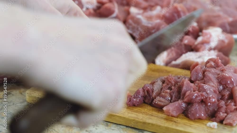 Close-up woman hands cutting a big piece of beef into a small pieces for stroganoff. Close-up woman hands cutting a big piece of beef into a small pieces for stroganoff.
