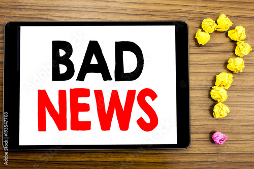 Writing text showing Bad News. Business concept for Failure Media Newspaper written on tablet computer on the wooden background with question mark made of folded paper. photo