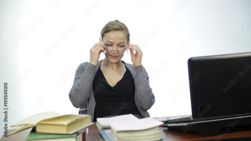 female teacher checks homework in classroom in front of laptop female teacher checks homework in classroom in front of laptop