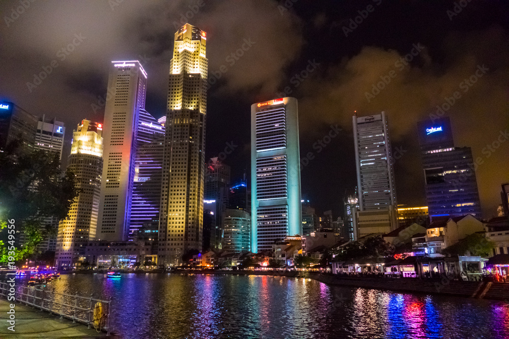 Obraz premium Singapore City, Singapore - 07 19 2015: Singapore Reflection Of Modern High Skyscraper Buildings And Its River At Colorful Night.