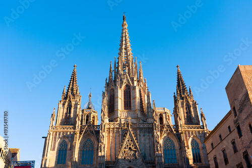 front view of barcelona cathedral facade during summer evening at sunset with blue sky