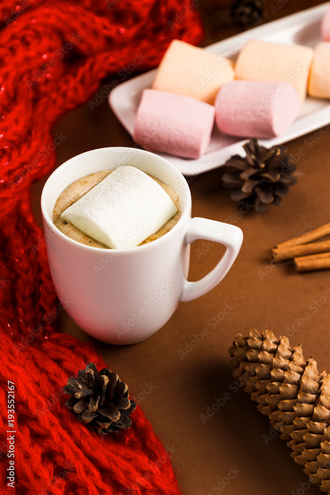 Drink hot chocolate with marshmallow near pine cones, red scarf and cinnamon sticks Drink hot chocolate with marshmallow near pine cones, red scarf and cinnamon sticks