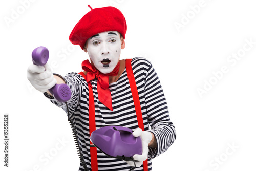 shocked mime giving ultra violet retro stationary telephone isolated on white