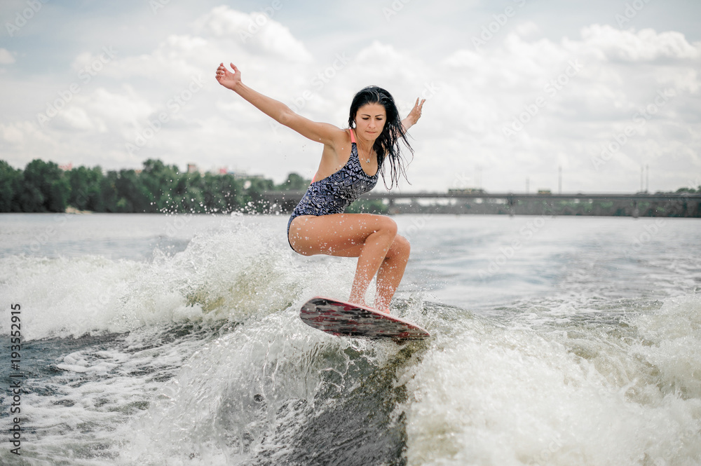 brunette woman with long hair riding wakeboard