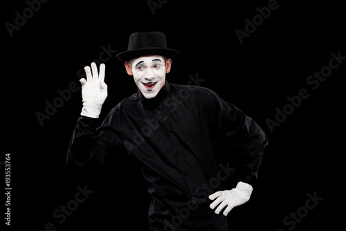happy mime waving hand isolated on black