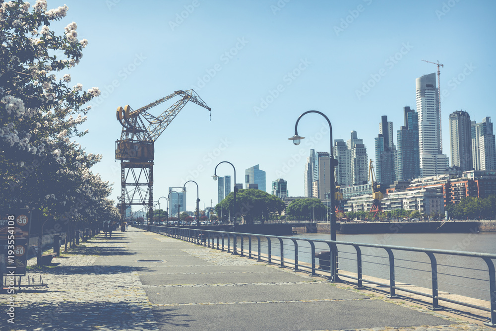 Old cranes in Puerto Madero Waterfront district. Modern skyline at sunny day.