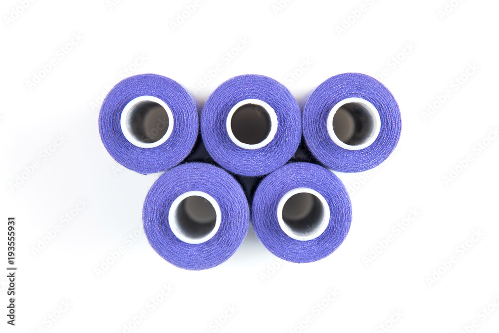 Five purple sewing threads on a white coils on a white background. Sewing supplies Five purple sewing threads on a white coils on a white background. Sewing supplies