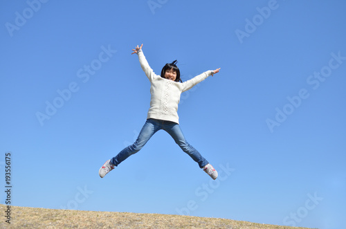 青空でジャンプする女の子 © hanapon1002