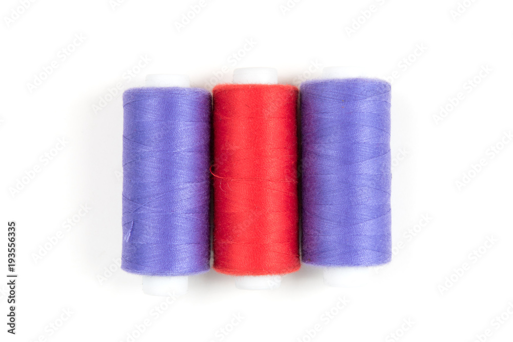Red and purple sewing threads on a white background. Set of three sewing threads. Red and purple sewing threads on a white background. Set of three sewing threads.