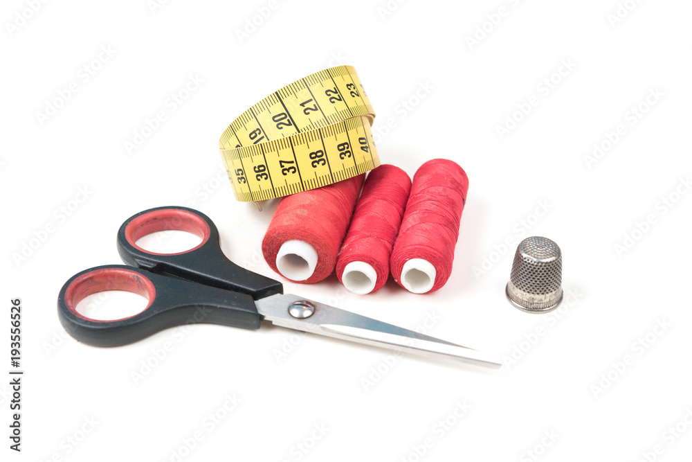 Sewing accessories and tools. Red sewing threads, black scissors