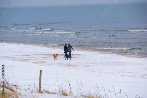 Fototapeta Naklejka Na Ścianę i Meble -  people walking on beach covered with snow