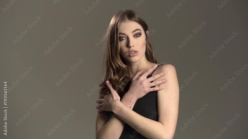 Fashion model portrait, girl with brown eyes and expressive mouth, on a on a gray background