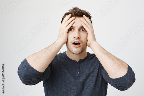 Foto Stressed frustrated dark-haired young male with stubble dressed in casual clothe
