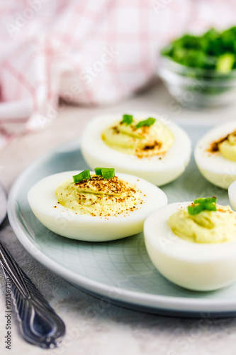 Sour cream deviled eggs with paprika and chives on white background. Selective focus  space for text. 