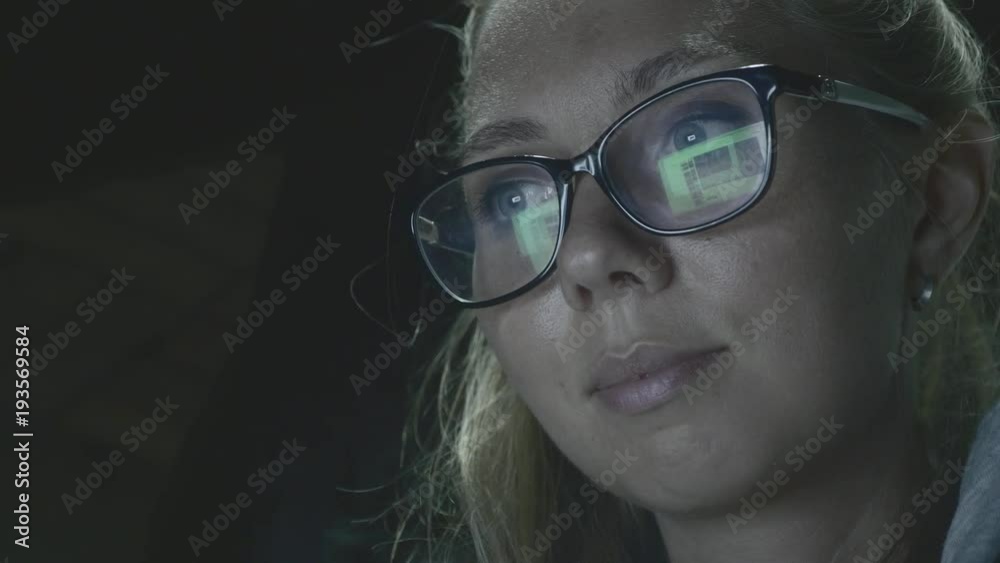 Hipster student girl browsing the internet,looking at monitor of modern laptop,closeup shot of screen reflection in glasses.Attractive young businesswoman working at night via computer at office Hipster student girl browsing the internet,looking at monitor of modern laptop,closeup shot of screen reflection in glasses.Attractive young businesswoman working at night via computer at office