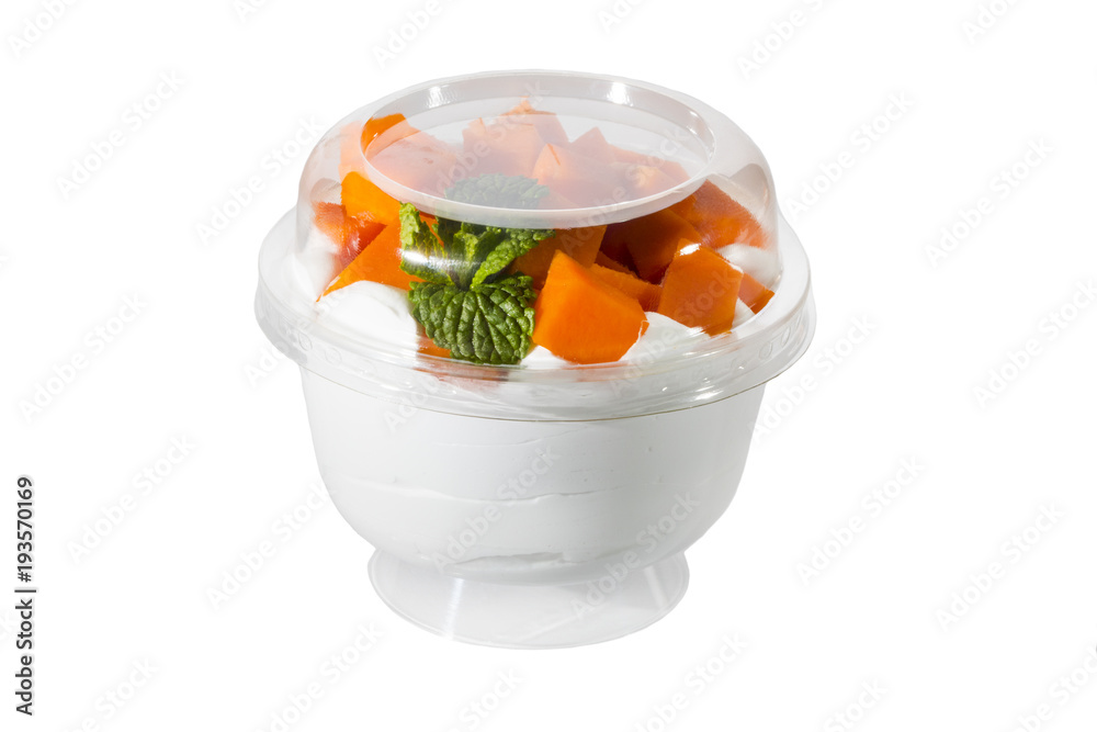 Creamy cream dessert in a plastic cup decorated with berries on a white background. Creamy cream dessert in a plastic cup decorated with berries on a white background.