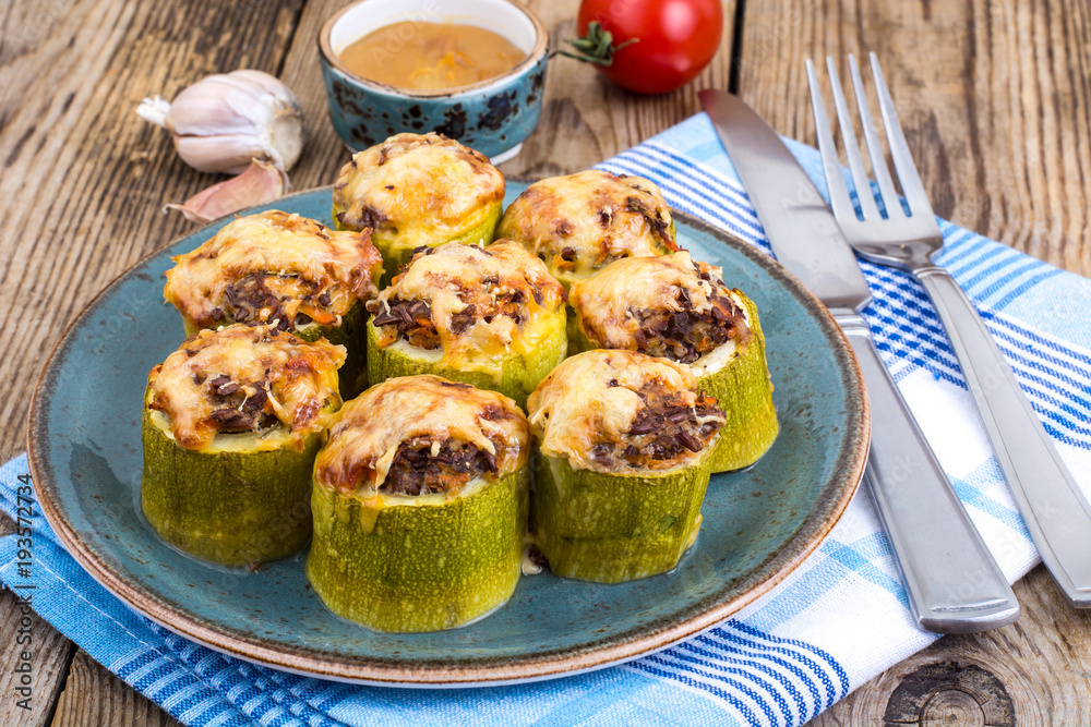 Zucchini stuffed with meat and cheese on blue plate Zucchini stuffed with meat and cheese on blue plate