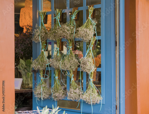 Bouquet of dried flowers hanging on the blue door