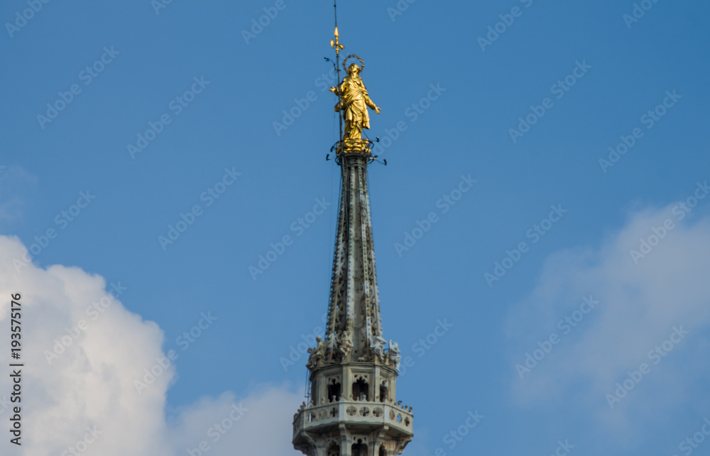 the golden statue of the Madonnina, from the spiers of the Duomo dominates Milan the golden statue of the Madonnina, from the spiers of the Duomo dominates Milan