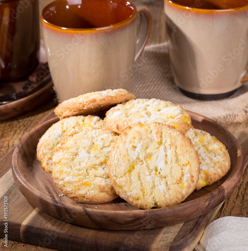 Pile of lemon crackle cookies on a wooden plate photo