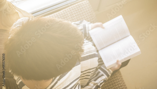 Pregnant woman reading book near window. light toning