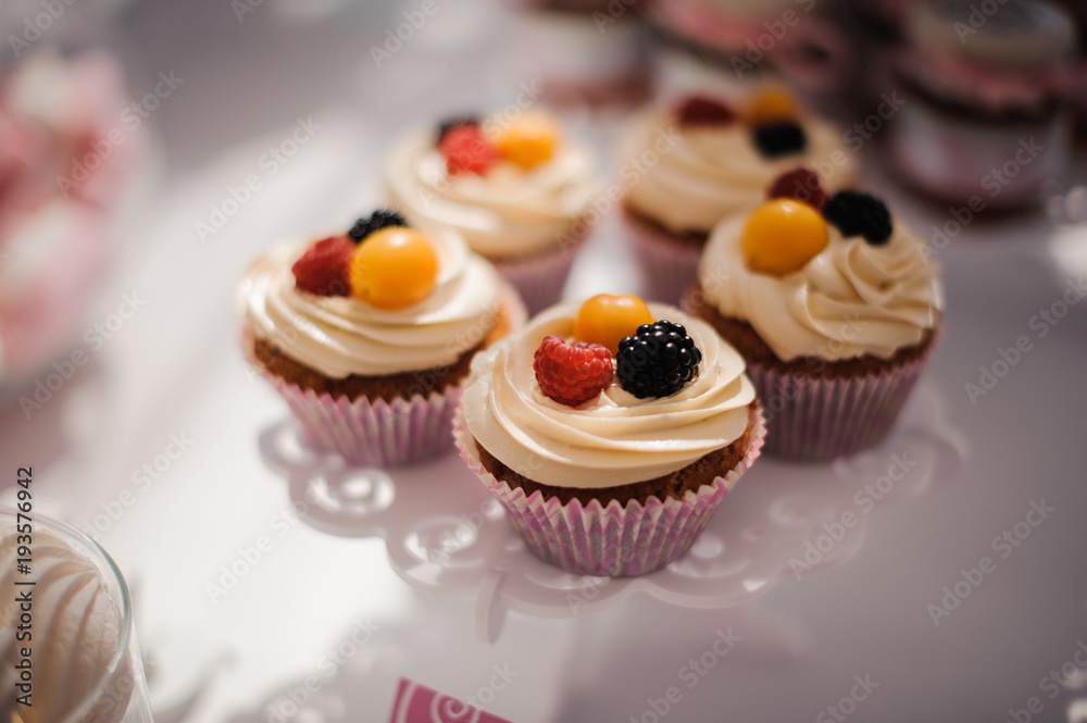 Tasty cupcakes with cream decorated with berries Tasty cupcakes with cream decorated with berries