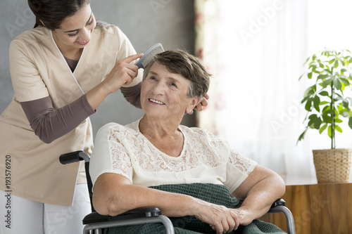 Volunteer combing odler patient's hair