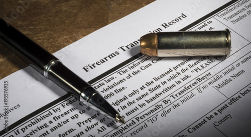 FBI gun background check form 4473 with pen and bullet photo