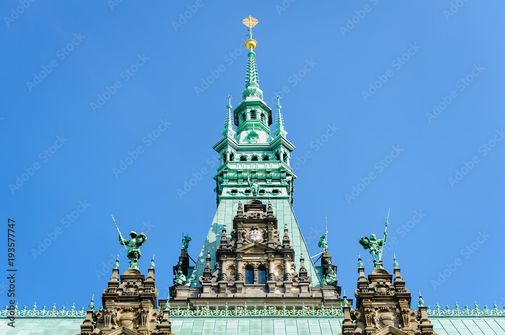 Top of the tower of Town Hall Hamburg under blue sky. View from courtyard.