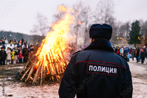A policeman on the background of a fire in the forest