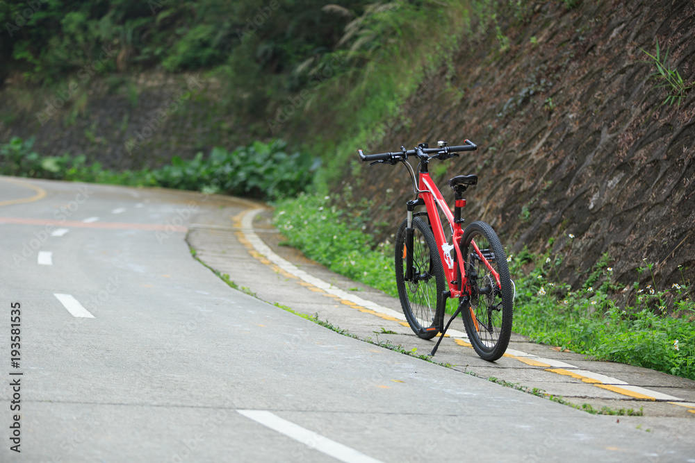 Fototapeta premium One red mountain bike on roadside of trail