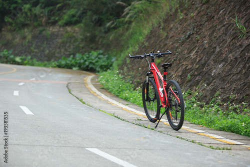 One red mountain bike on roadside of trail