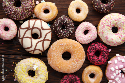 assorted donuts with chocolate frosted, pink glazed and sprinkles donuts.