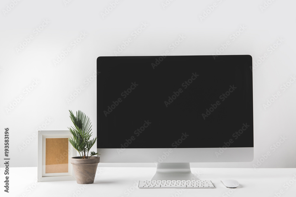 desktop computer with blank screen, empty frame and houseplant in pot desktop computer with blank screen, empty frame and houseplant in pot