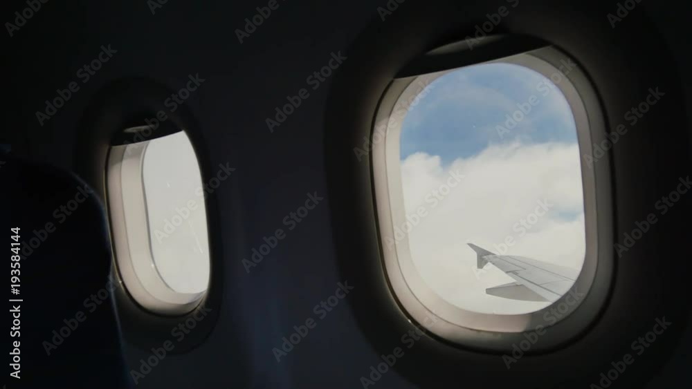 Looking out the window of an airplane as clouds pass by. Looking out the window of an airplane as clouds pass by.