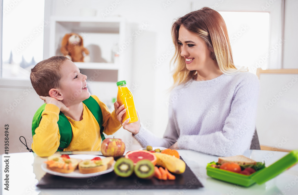 Mother making breakfast for her children in the morning and a snack for school Mother making breakfast for her children in the morning and a snack for school