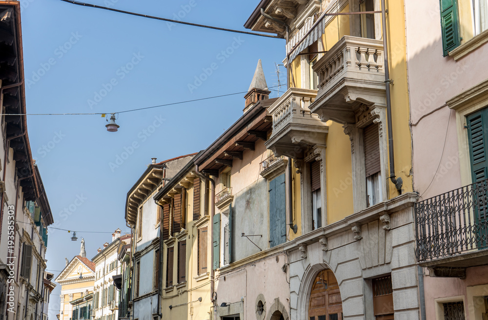 mediterranean facades /  Street with pretty, beautiful, houses in Verona with balconies and blue sky 