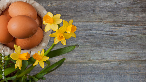 chicken eggs lying in a basket, on a neutral background with flowers