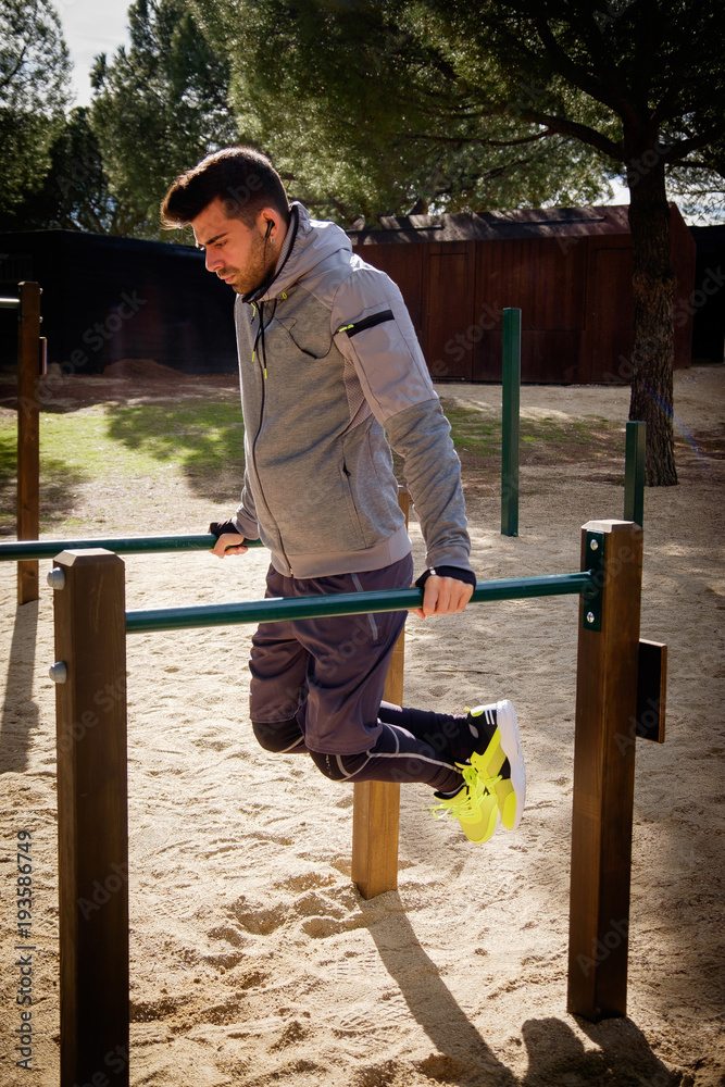 Young athlete man is doing exercise in a park Young athlete man is doing exercise in a park