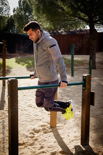 Young athlete man is doing exercise in a park