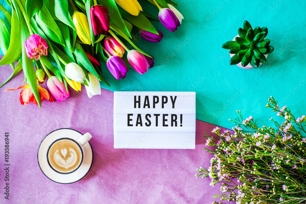 Fototapeta Happy easter written in lightbox with easter decorations from above