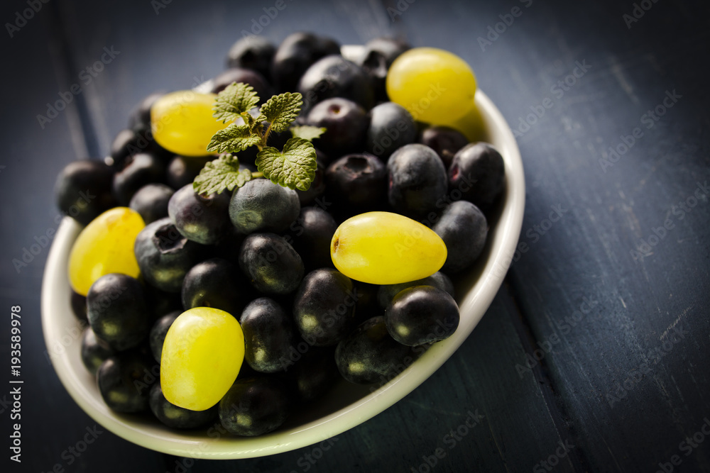 Blueberries and grapes on white bowl Blueberries and grapes on white bowl