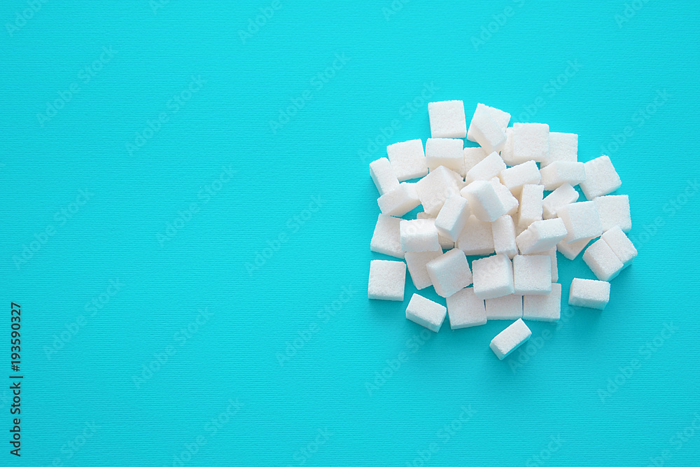 Sugar cubes scattered on a blue background with an empty space for text copy paste Sugar cubes scattered on a blue background with an empty space for text copy paste
