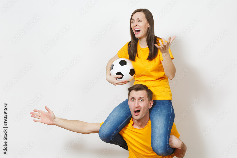 Inspired young couple, woman sit on man shoulders, fans with soccer ball cheering favorite football team expressive gesticulating hands isolated on white background. Family leisure, lifestyle concept. Inspired young couple, woman sit on man shoulders, fans with soccer ball cheering favorite football team expressive gesticulating hands isolated on white background. Family leisure, lifestyle concept.