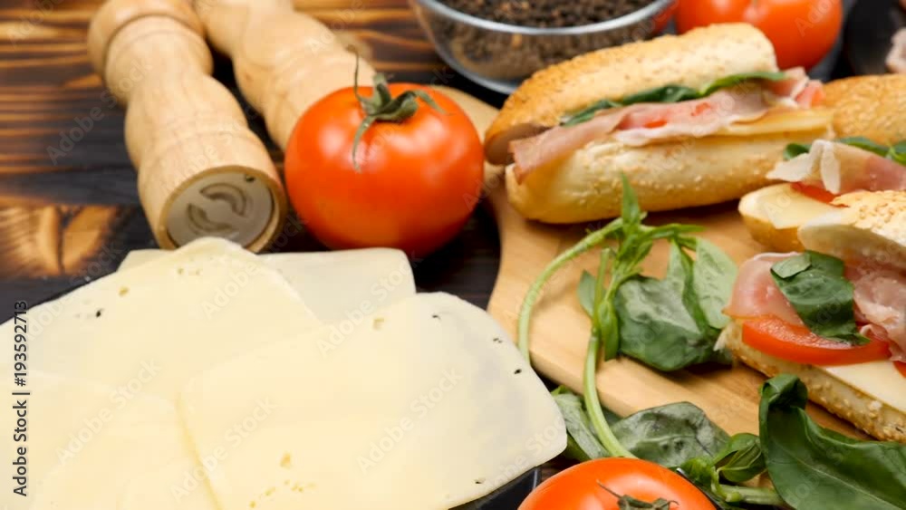 Four healthy and delicious sandwiches lying on wooden board on a table. Dolly shot from left to right Four healthy and delicious sandwiches lying on wooden board on a table. Dolly shot from left to right
