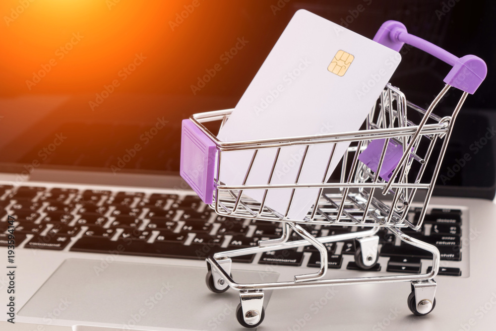 credit card in shopping cart on laptop keyboard. Online shopping concept