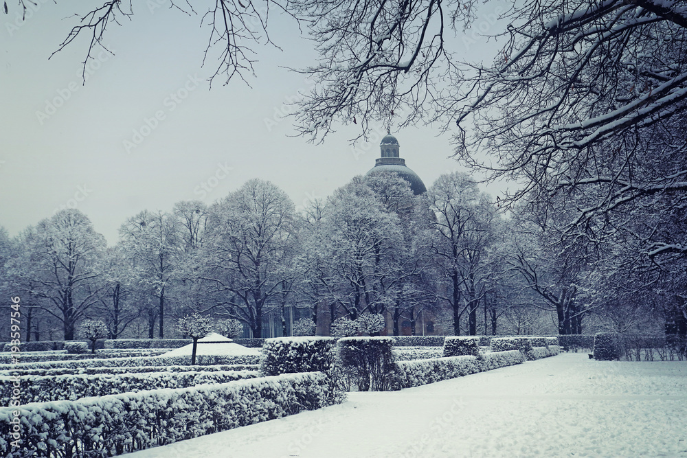 Munich, Germany, winter view with snow of the Hofgarten  baroque garden built in XVII century, withs the dome of Bavarian State Chancellery framed by trees